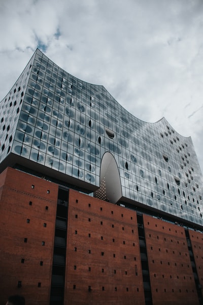 Brown and grey concrete building under the white clouds during the day
